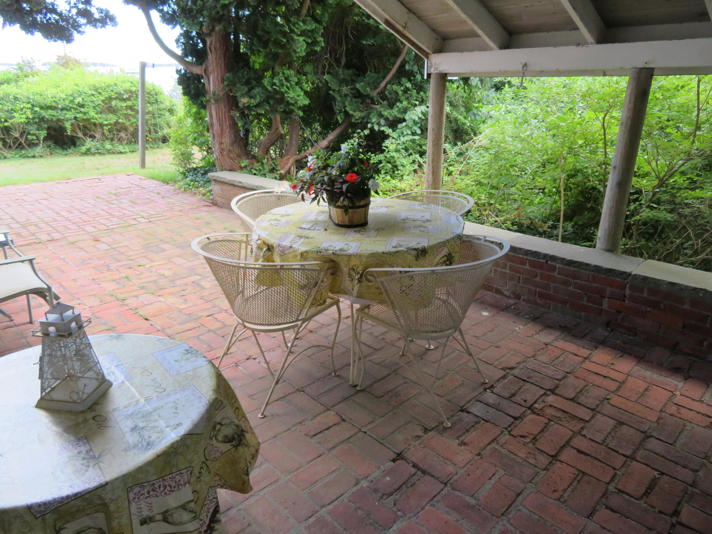75 Harbor Bluff Road Hyannis, MA 02601 - Photo 25 of 31 a table and chairs sitting in a backyard