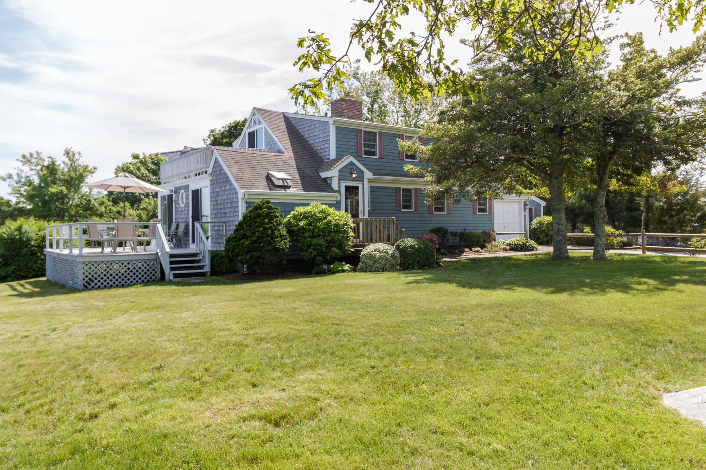75 Harbor Bluff Road Hyannis, MA 02601 - Photo 31 of 31 a front view of a house with a garden and trees