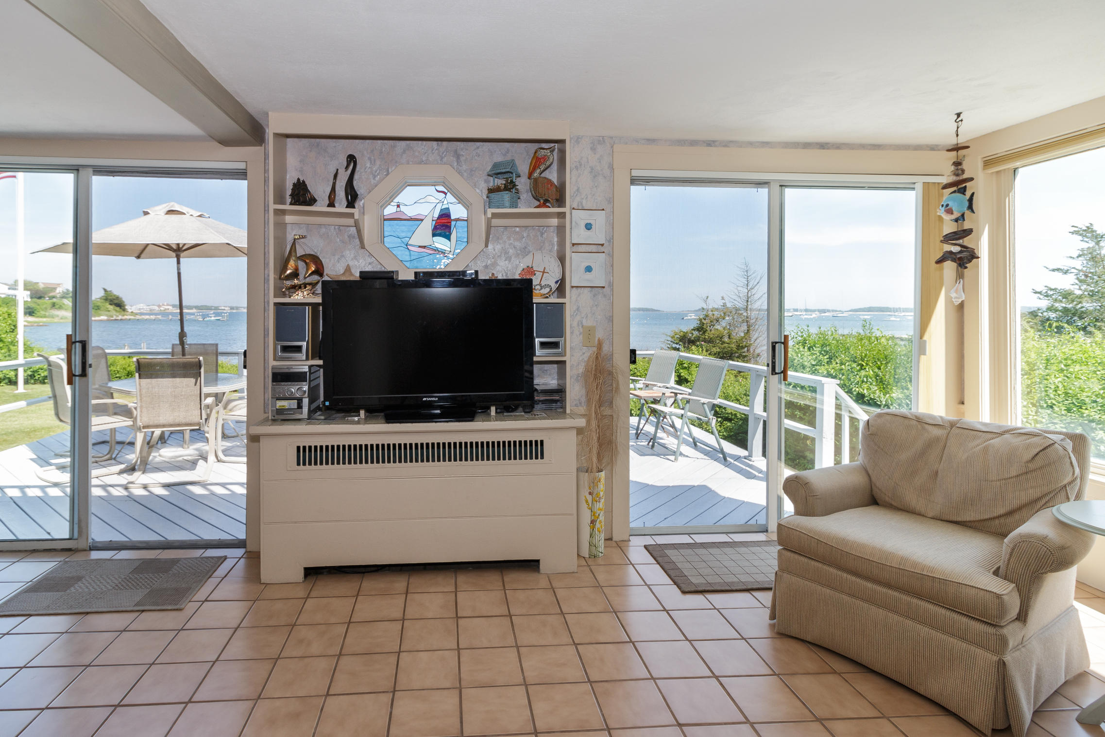 75 Harbor Bluff Road Hyannis, MA 02601 - Photo 10 of 31 a living room with furniture a flat screen tv and a floor to ceiling window