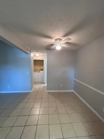 a view of an empty room with a chandelier fan