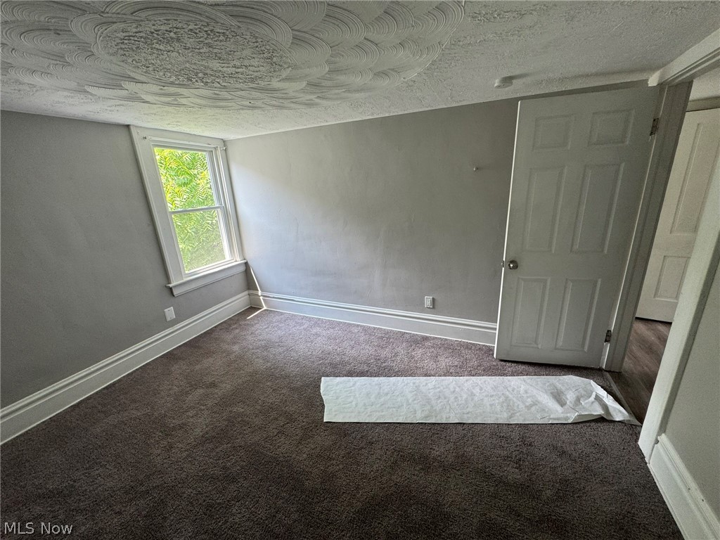 674-676 Carlysle Street Akron, OH 44310 - Photo 13 of 20 Bedroom 2 on second floor featuring a single window, textured ceiling, gray wall finish, white baseboards, and brown carpet flooring