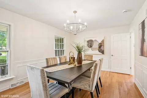 a view of a dining room with furniture a chandelier and wooden floor