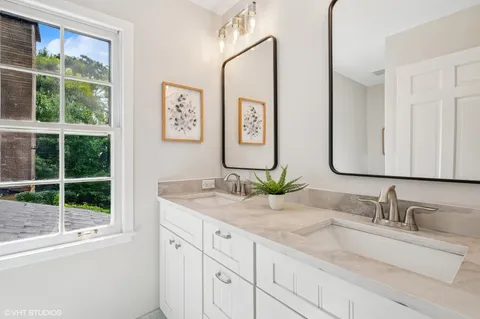 a bathroom with double vanity sink and a window