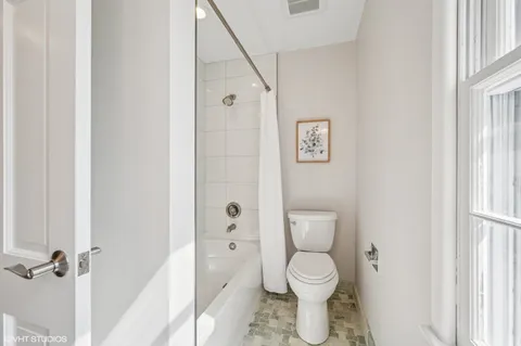 a bathroom with a toilet and a shower