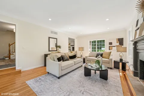 a living room with furniture large window and wooden floor