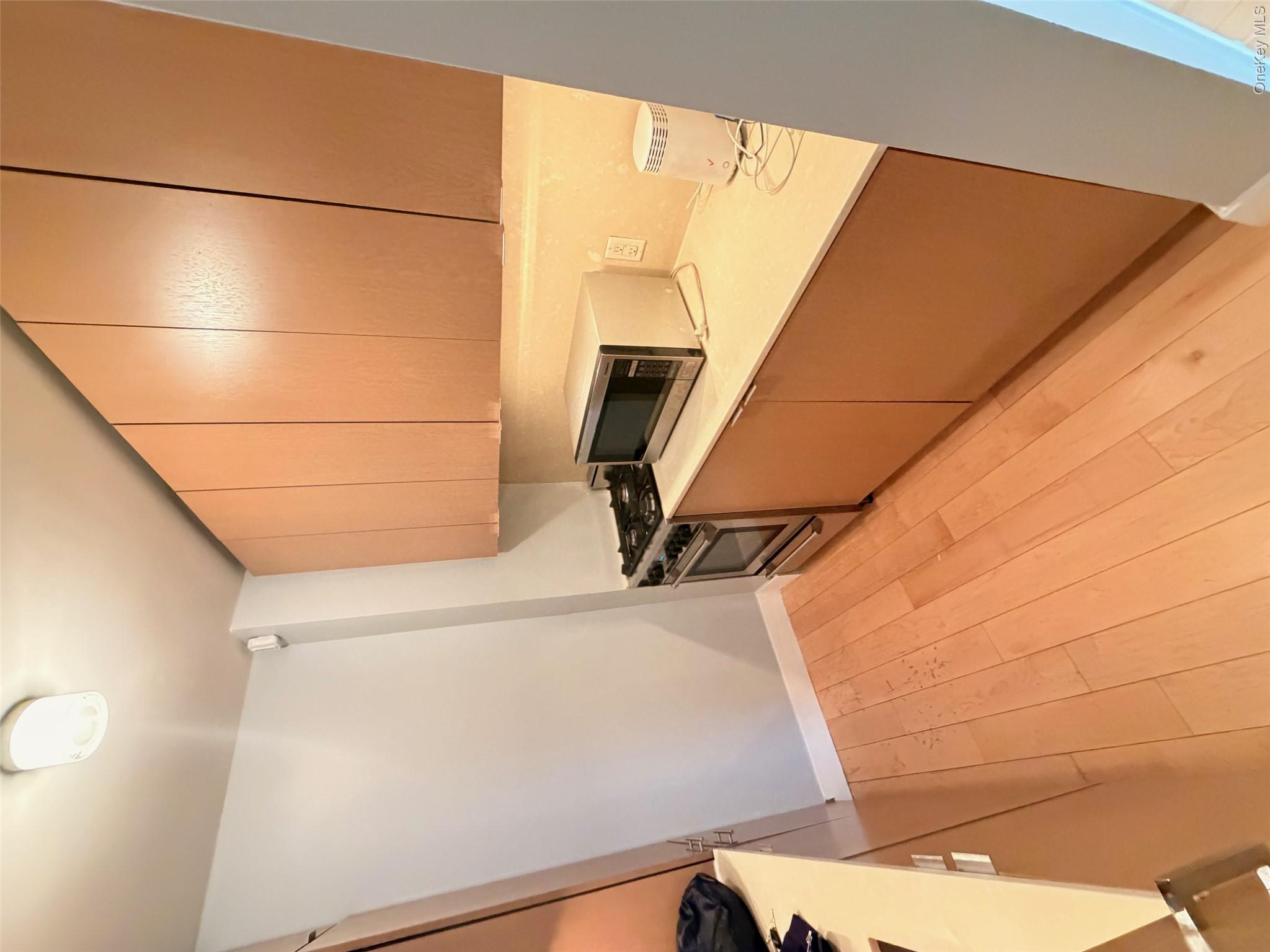 225 Rector Place, Unit 7E Manhattan, NY 10280 - Photo 11 of 19 Compact kitchen featuring light wood-finish flooring and flat-panel cabinetry