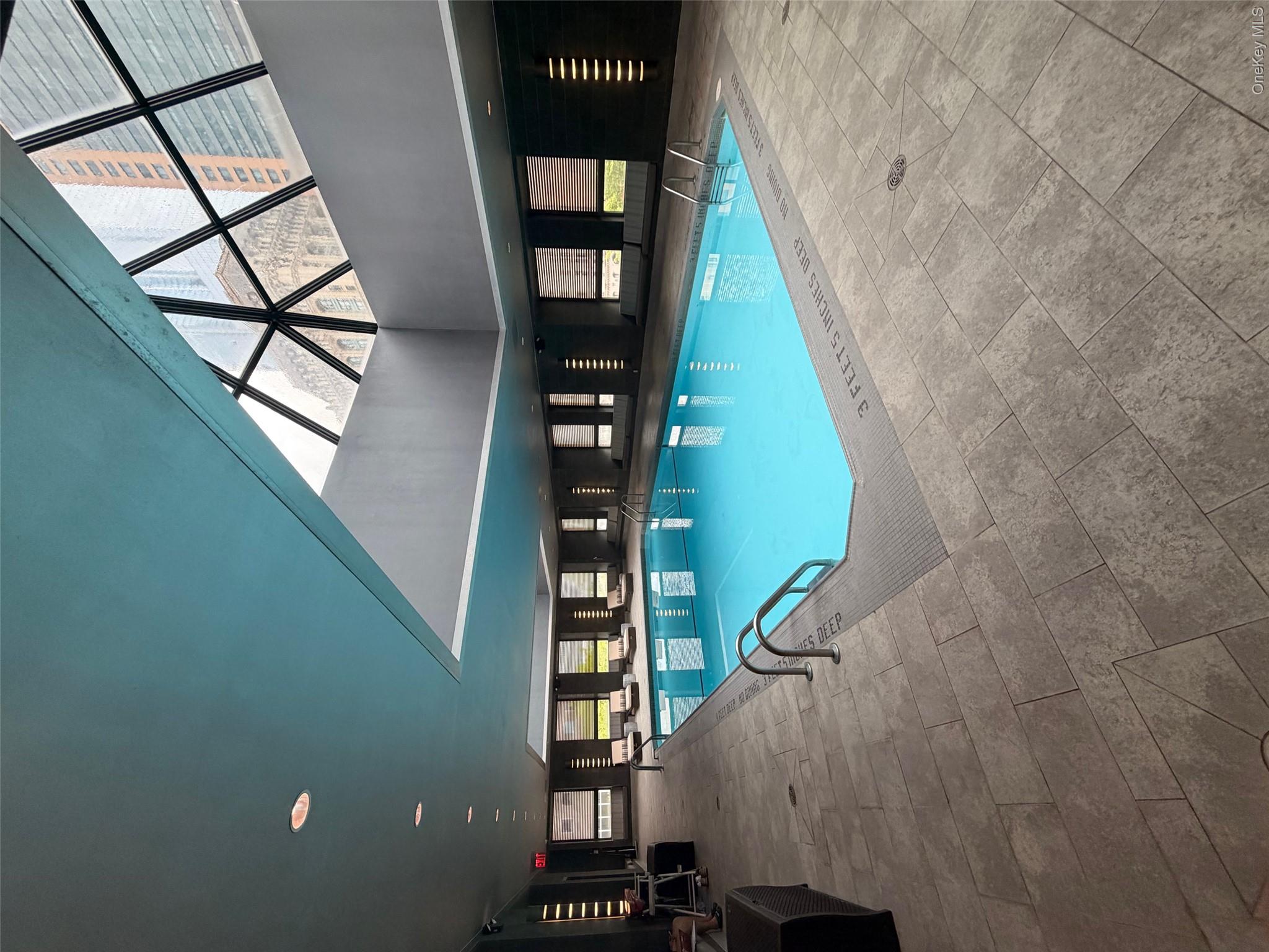 225 Rector Place, Unit 7E Manhattan, NY 10280 - Photo 15 of 19 Indoor swimming pool featuring a geometric skylight, recessed ceiling lighting, and perimeter windows