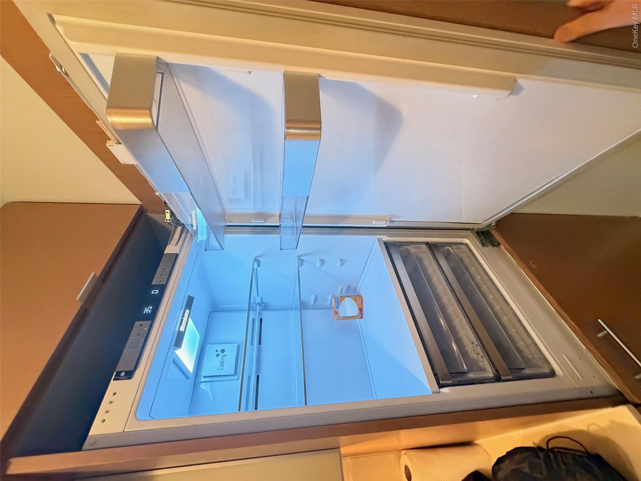 225 Rector Place, Unit 7E Manhattan, NY 10280 - Photo 9 of 19 Built-in refrigerator with a digital temperature display, bright interior lighting, multiple adjustable glass shelves, and two transparent crisper drawers