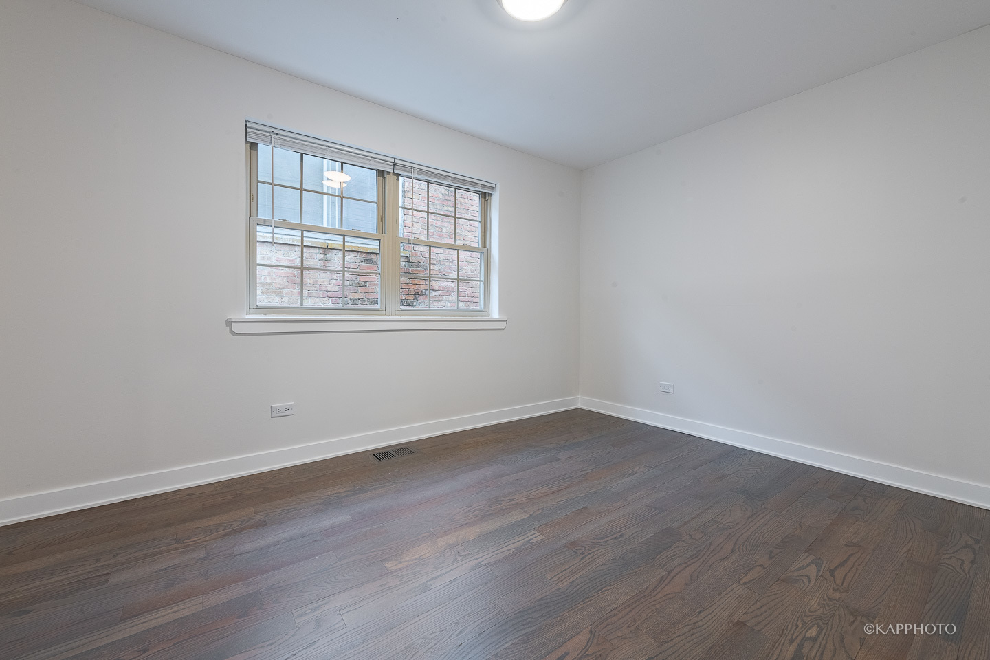 5654 South Princeton Avenue Chicago, IL 60621 - Photo 15 of 29 an empty room with wooden floor and windows