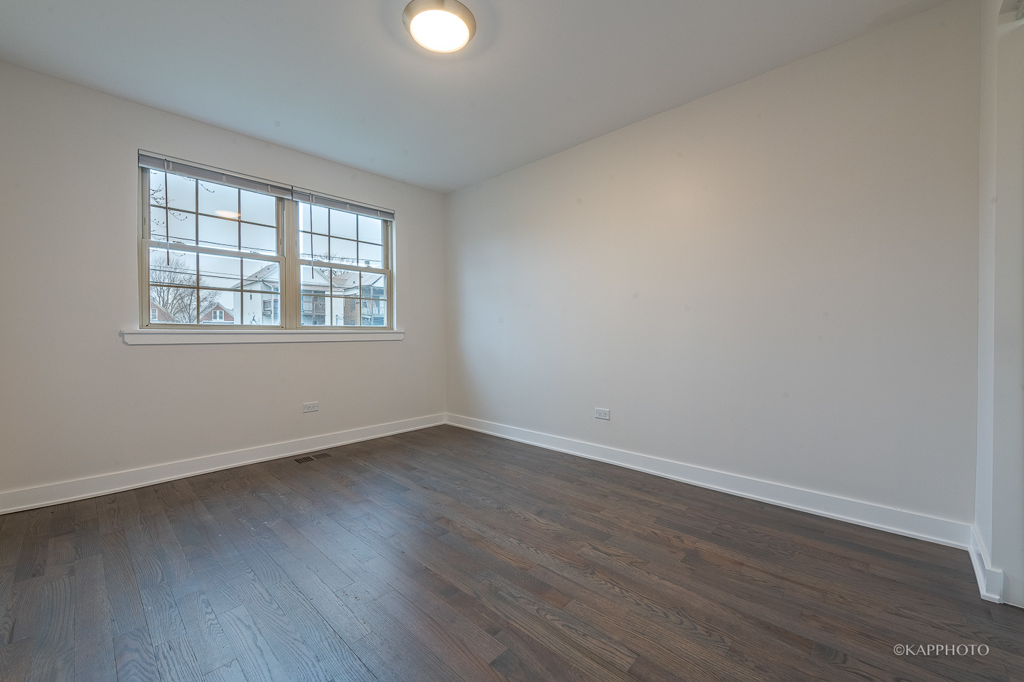 5654 South Princeton Avenue Chicago, IL 60621 - Photo 19 of 29 an empty room with wooden floor and windows
