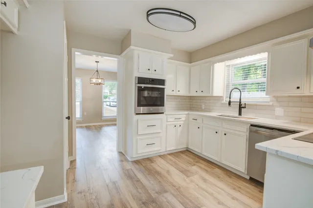 a kitchen with white cabinets and stainless steel appliances