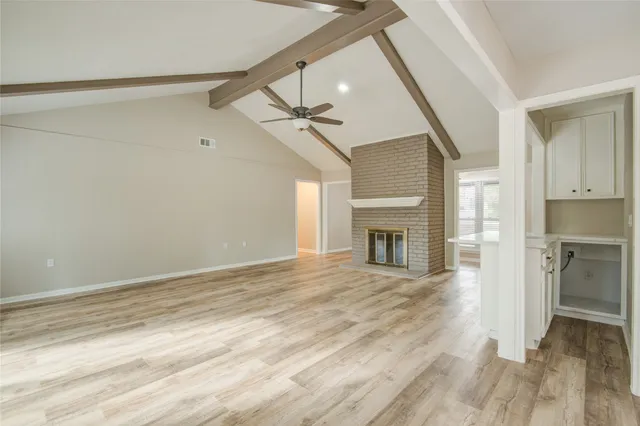 a view of an empty room with a fireplace and a window