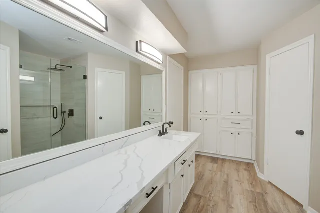 a bathroom with a double vanity sink and mirror with shower