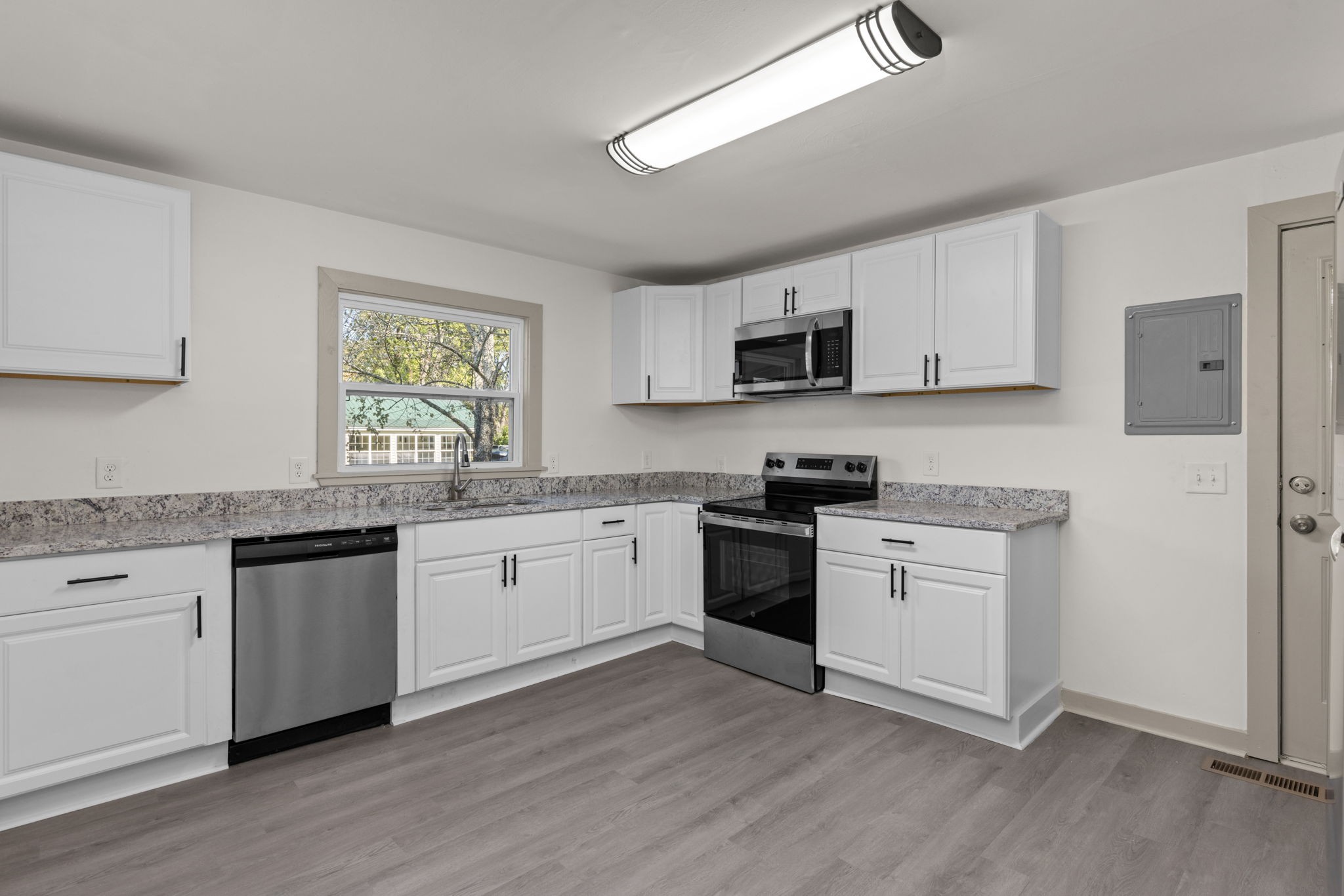 503 5th Street Lawrenceburg, TN 38464 - Photo 3 of 19 a kitchen with granite countertop white cabinets and white appliances