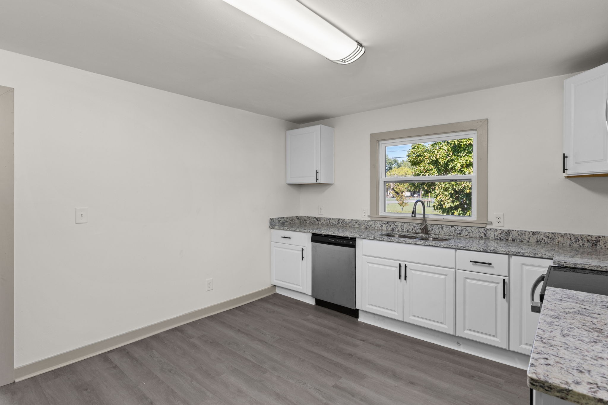 503 5th Street Lawrenceburg, TN 38464 - Photo 6 of 19 a kitchen with granite countertop a sink cabinets a window and stainless steel appliances