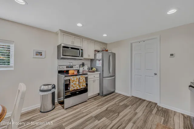 a kitchen with stainless steel appliances a refrigerator and a stove top oven