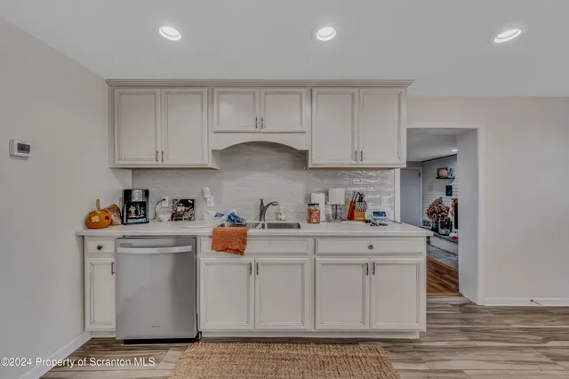 a kitchen with white cabinets and sink