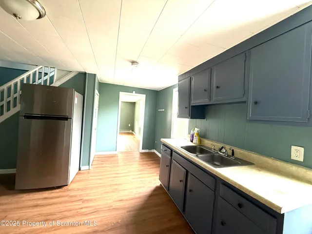 a kitchen with stainless steel appliances granite countertop a refrigerator a sink and a stove