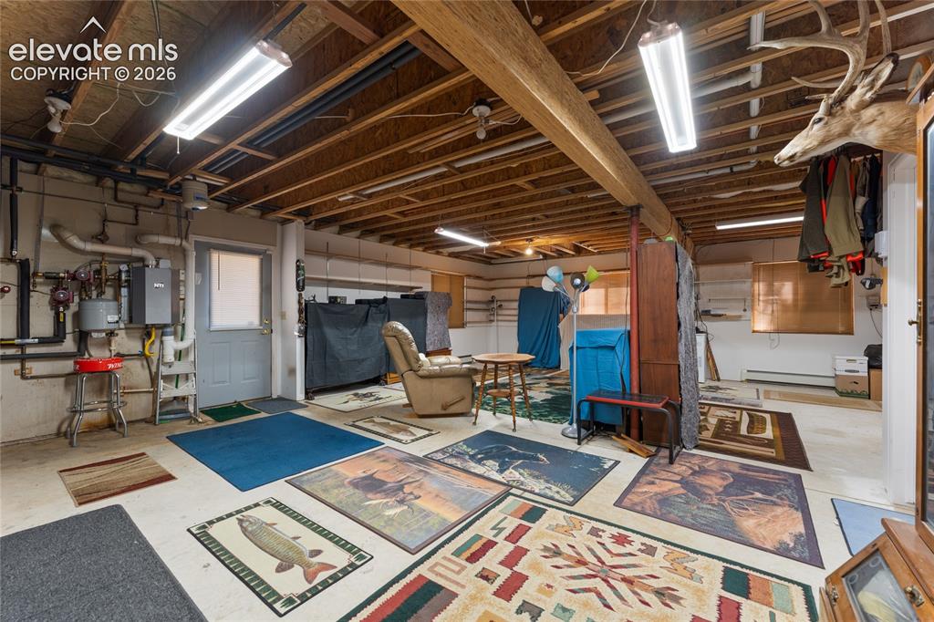 657 Spring Valley Drive Divide, CO 80814 - Photo 33 of 43 Spacious unfinished basement offering exposed wooden ceiling joists, concrete flooring, and multiple ceiling-mounted fluorescent light fixtures