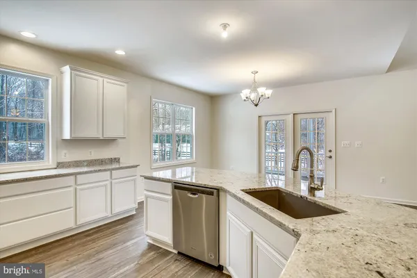 a kitchen with granite countertop a sink stove and cabinets