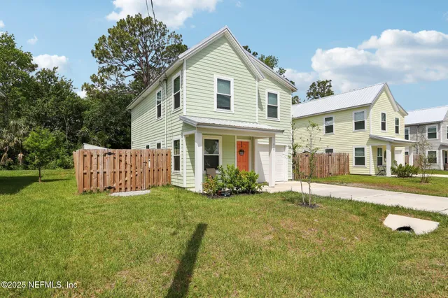 a view of a house with a yard and porch