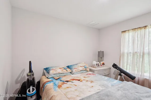 a bed sitting in a bedroom next to a window