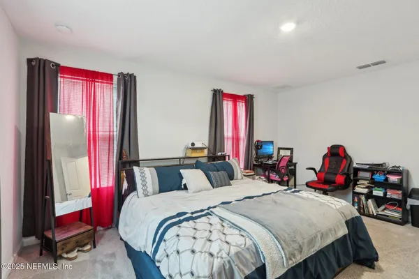 a bedroom with bed and a mirror