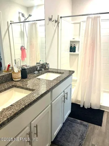 a bathroom with a granite countertop sink and a mirror