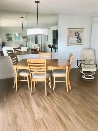 a dining room with wooden floor a glass table and chairs