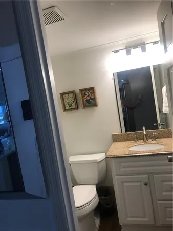 a bathroom with a toilet sink and mirror