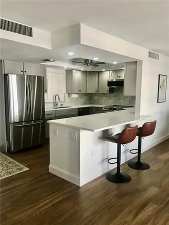a kitchen with stainless steel appliances granite countertop a sink a stove and a refrigerator
