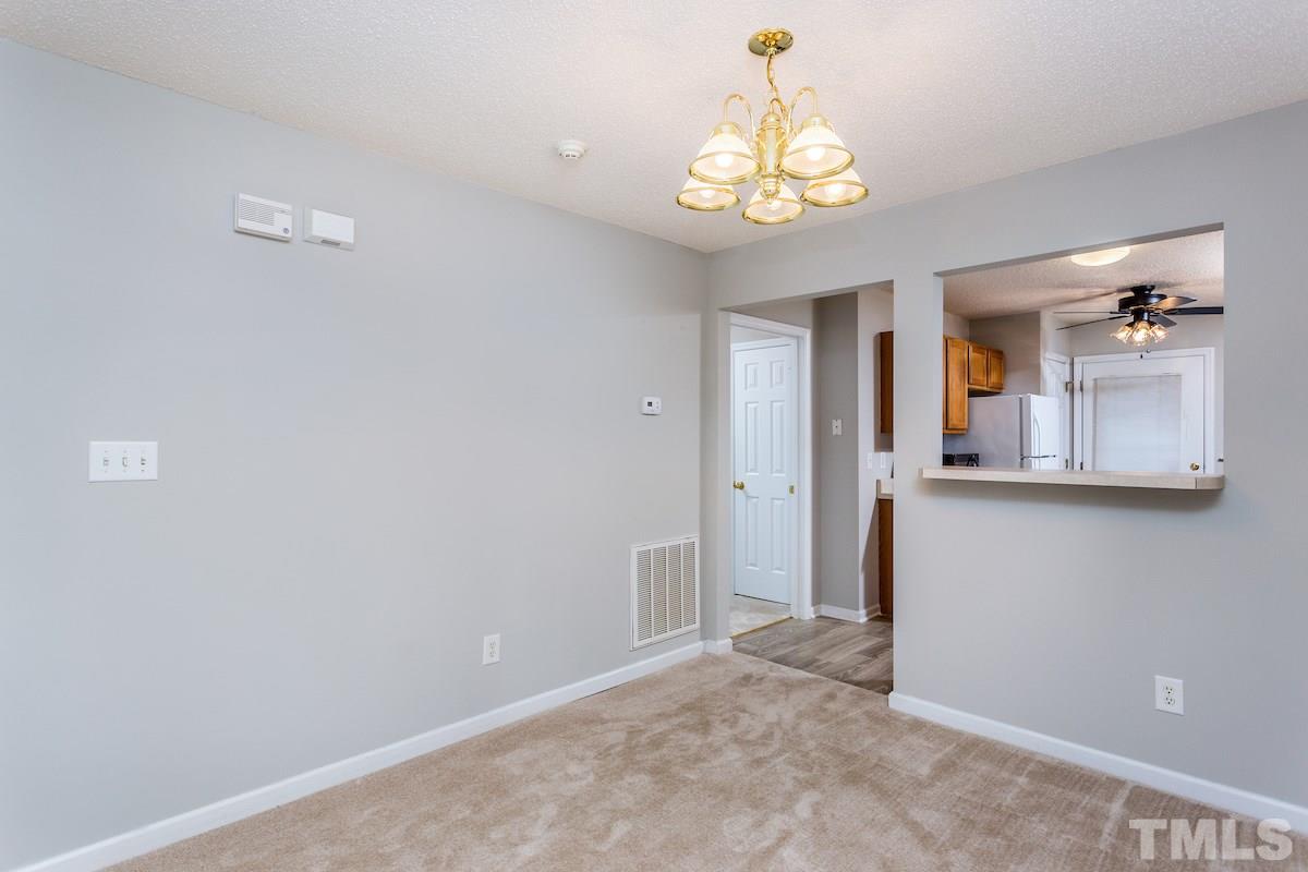 3752 Votive Lane Raleigh, NC 27604 - Photo 8 of 22 a view of a hallway with a chandelier fan and wooden floor