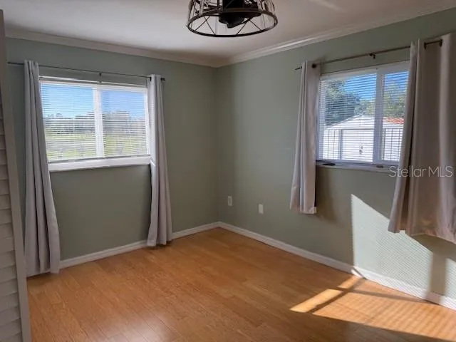 a view of a livingroom with wooden floor and kitchen space