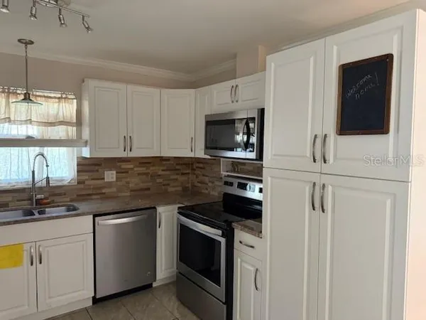 a kitchen with cabinets stainless steel appliances and a sink