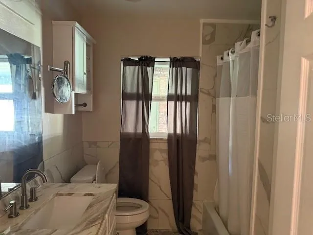 a bathroom with a toilet sink and shower