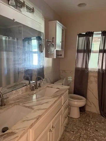 a bathroom with a sink toilet and shower