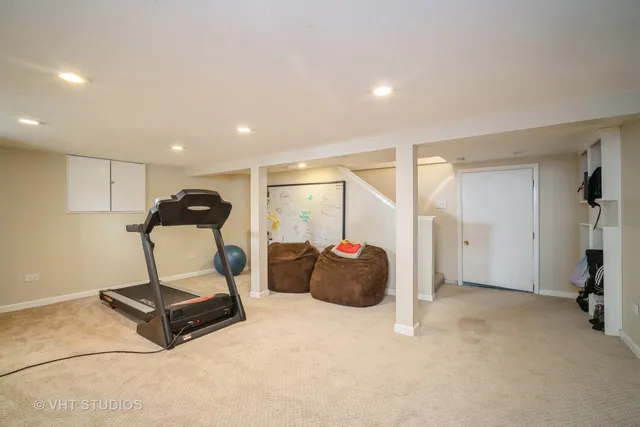 a living room with furniture and a gym machine