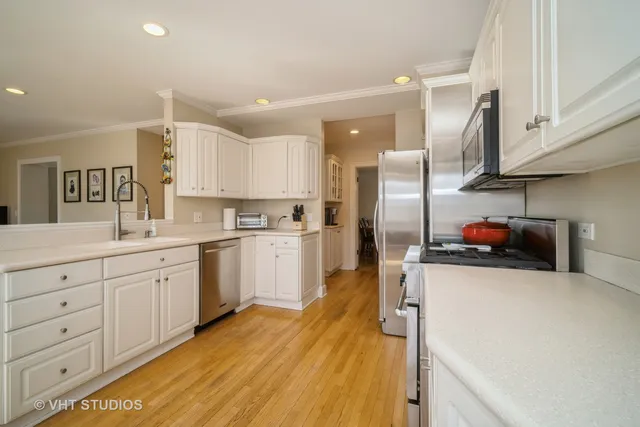 a kitchen with stainless steel appliances a refrigerator sink and white cabinets