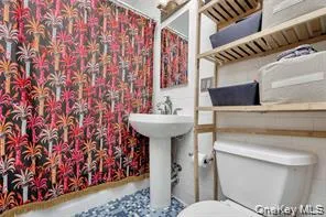 a bathroom with a sink toilet and mirror