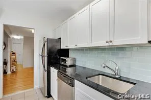 a kitchen with stainless steel appliances granite countertop a sink a stove and a refrigerator