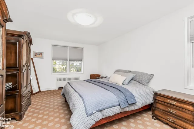 a bedroom with a bed and a flat tv screen on a dresser