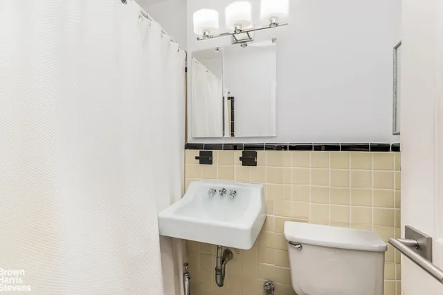 a bathroom with a sink a toilet and a mirror