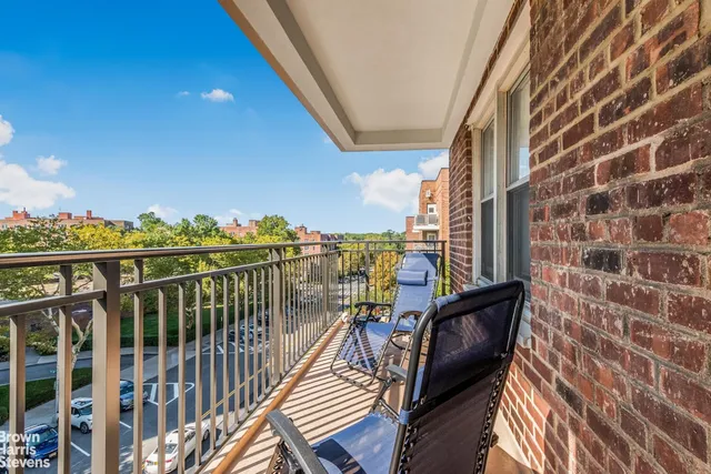 a view of a balcony with wooden chairs