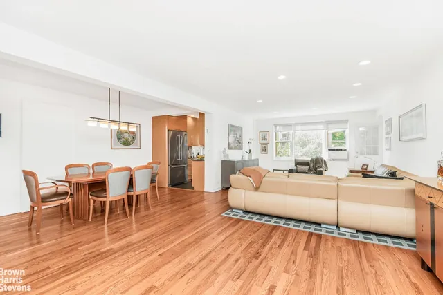 a living room with furniture a wooden floor and next to a window