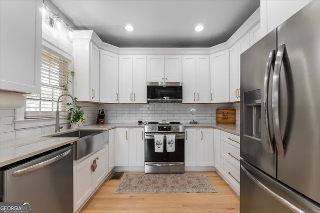 a kitchen with stainless steel appliances a refrigerator sink and microwave