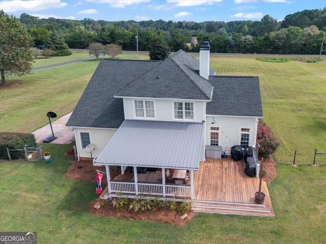an aerial view of a house with a garden and lake view