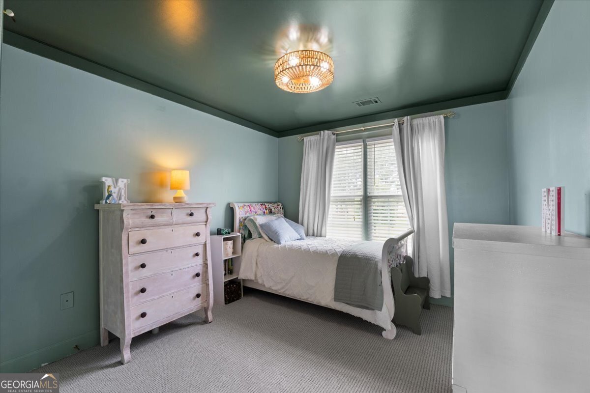 1670 Price Mill Road Bishop, GA 30621 - Photo 42 of 53 a spacious bedroom with a bed and a chandelier