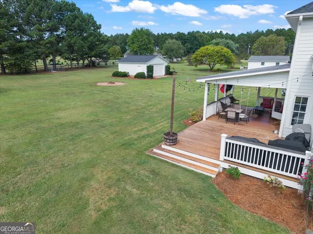 a view of a deck with a table and chairs next to a yard
