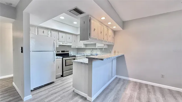 a kitchen with kitchen island a sink stainless steel appliances and cabinets