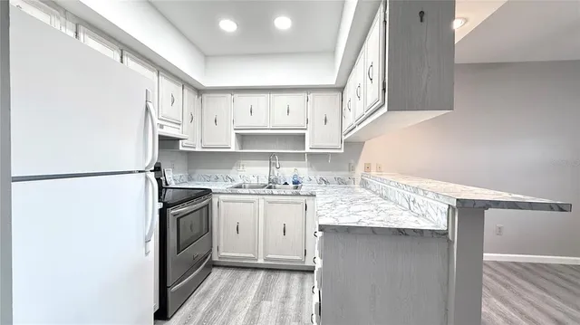 a kitchen with stainless steel appliances granite countertop a sink stove and refrigerator